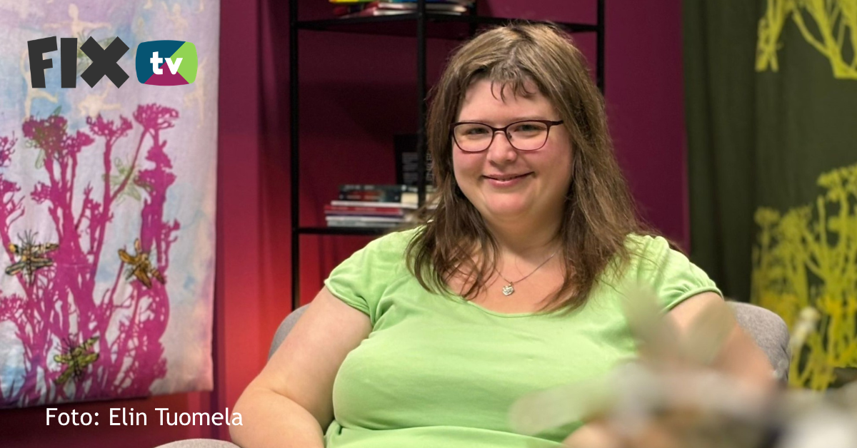 Nathalie har långt brunt hår och glasögon. Hon ser glad ut.
