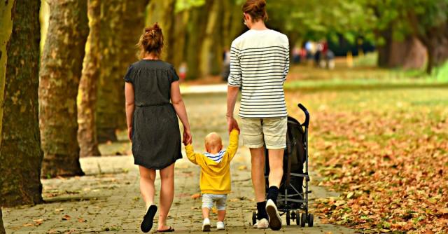 Ett barn som håller sin mamma och pappa i handen