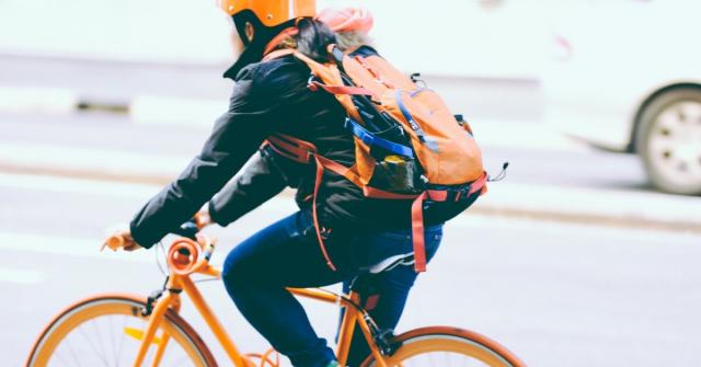 Cyklist med hjälm på cykle i trafiken